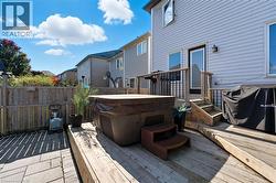Wooden deck featuring area for grilling and a hot tub - 