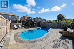 View of pool with a fenced backyard, a patio area, and a storage shed - 