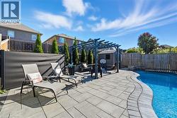 View of pool with a fenced backyard, a pergola, a patio, and a storage unit - 
