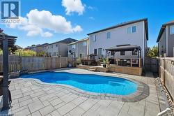 View of pool featuring a gazebo, a hot tub, a fenced backyard, and a wooden deck - 