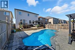 View of swimming pool featuring a gazebo, a residential view, a patio, a fenced backyard, and a wooden deck - 