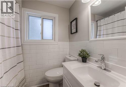 Bathroom featuring vanity, tile walls, a shower with shower curtain, and wainscoting - 156 Donald Street, Kitchener, ON - Indoor Photo Showing Bathroom