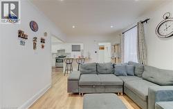Living area with light wood-style floors and ornamental molding - 