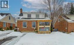 View of front of home with a chimney and brick siding - 
