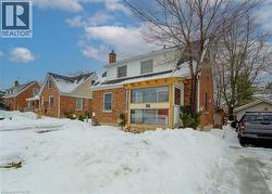 View of front of home featuring a chimney and brick siding - 