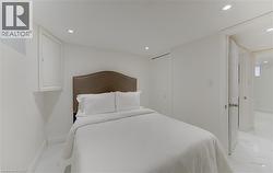 Bedroom featuring light marble finish floors, a closet, and recessed lighting - 