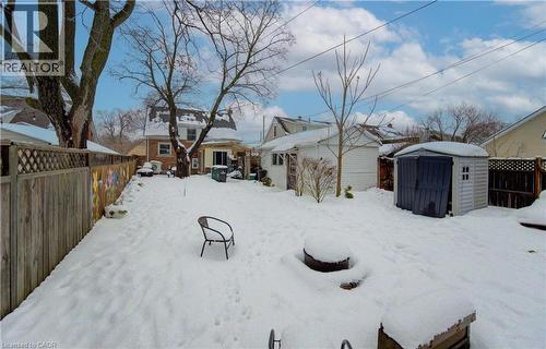 Yard layered in snow featuring a fenced backyard and a shed - 569 Stirling Avenue S, Kitchener, ON - Outdoor