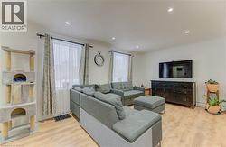 Living area with light wood-type flooring, recessed lighting, and crown molding - 