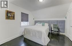 Bedroom featuring vaulted ceiling and dark wood-style floors - 