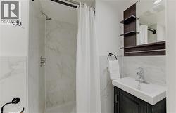 Full bathroom with vanity and a marble finish shower - 