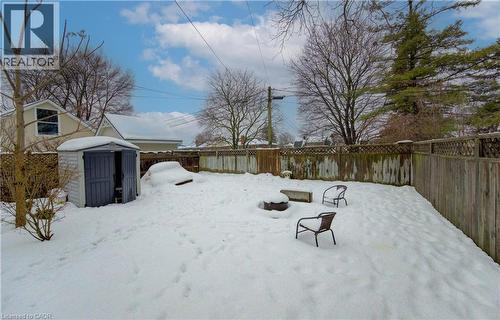 Snowy yard featuring a fenced backyard and a storage unit - 569 Stirling Avenue S, Kitchener, ON - Outdoor