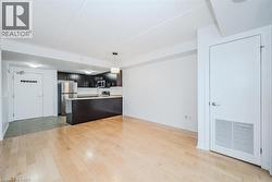 Kitchen with a peninsula, light countertops, open floor plan, appliances with stainless steel finishes, and light wood finished floors - 