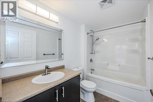 Bathroom with vanity, tub / shower combination, and dark tile patterned floors - 41 Goodwin Drive Unit# 202, Guelph, ON - Indoor Photo Showing Bathroom