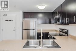 Kitchen featuring appliances with stainless steel finishes, light countertops, and backsplash - 
