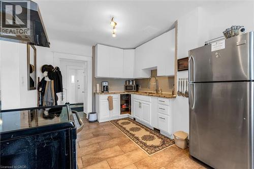 Kitchen with appliances with stainless steel finishes, ventilation hood, white cabinets, and dark stone counters - 35 Bayfield Avenue, Hamilton, ON - Indoor Photo Showing Kitchen With Stainless Steel Kitchen