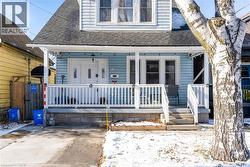 View of front facade featuring roof with shingles and covered porch - 