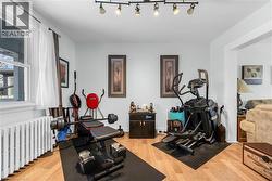 Exercise room with radiator and light wood-type flooring - 