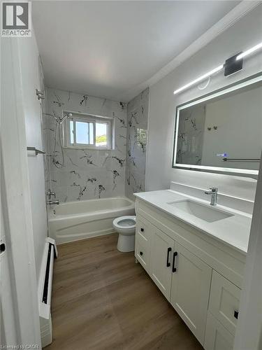 Bathroom with vanity, shower / tub combination, light wood-type flooring, and a baseboard radiator - 145 Macgregor Crescent Unit# 1, Waterloo, ON - Indoor Photo Showing Bathroom