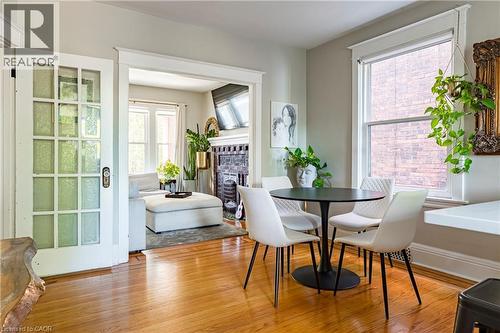 Dining space with a fireplace and light wood-type flooring - 58 Chatham Street, Hamilton, ON - Indoor Photo Showing Dining Room