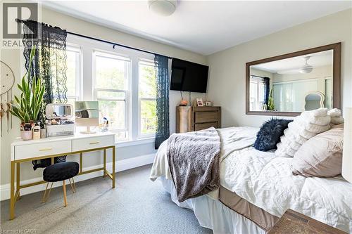 Bedroom with multiple windows, carpet flooring, and an office area - 58 Chatham Street, Hamilton, ON - Indoor Photo Showing Bedroom
