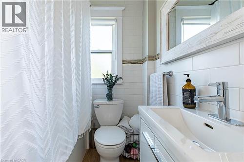 Full bath with vanity, tile walls, and curtained shower - 58 Chatham Street, Hamilton, ON - Indoor Photo Showing Bathroom