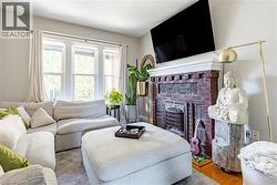 Living room featuring a brick fireplace and wood finished floors - 