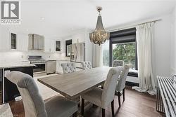 Dining space with dark wood finished floors and a chandelier - 