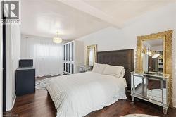 Bedroom with dark wood finished floors and beamed ceiling - 