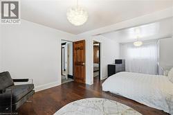 Bedroom with dark wood-type flooring and a chandelier - 