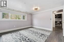 Spare room with dark wood-style flooring and ornamental molding - 