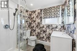 Bathroom with ornamental molding, vanity, a stall shower, and wood finished floors - 