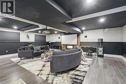 Living room featuring light wood finished floors, recessed lighting, wainscoting, and ornamental molding - 