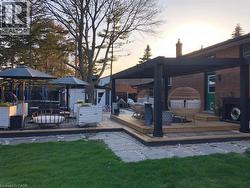 Yard at dusk with a deck, a lawn, and a shed - 