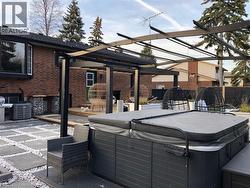 View of patio / terrace featuring a hot tub, a pergola, and grilling area - 