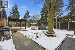 Yard layered in snow featuring a fenced backyard, a hot tub, a deck, and a pergola - 