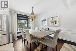 Dining space featuring a chandelier, plenty of natural light, and dark wood-style floors - 