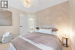 Bedroom with wood finished floors and a chandelier - 