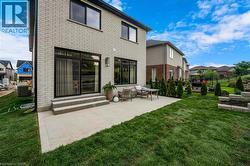 Back of house featuring brick siding, a lawn, a patio area, and entry steps - 