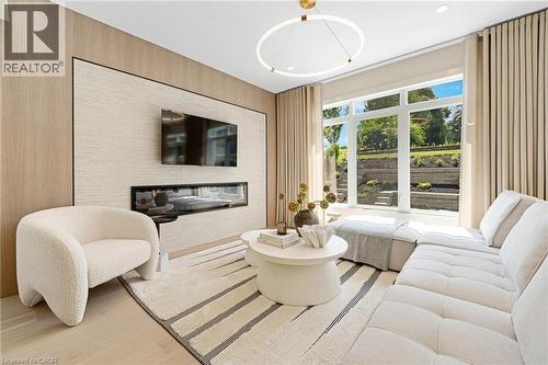 Living room with light wood-style flooring and a glass covered fireplace - 452 Westhaven Street, Waterloo, ON - Indoor Photo Showing Living Room