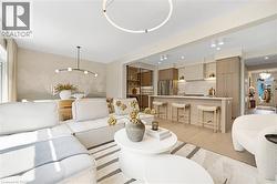Living area featuring a chandelier, light wood-type flooring, and recessed lighting - 