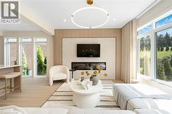Living area with light wood-type flooring, a glass covered fireplace, recessed lighting, and beam ceiling - 
