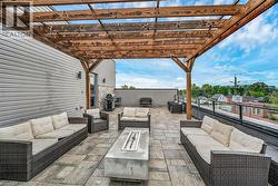 View of Rooftop patio featuring outdoor lounge area, a grill, and a pergola - 
