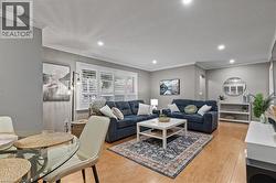 Living room featuring crown molding, light wood finished floors, and recessed lighting - 