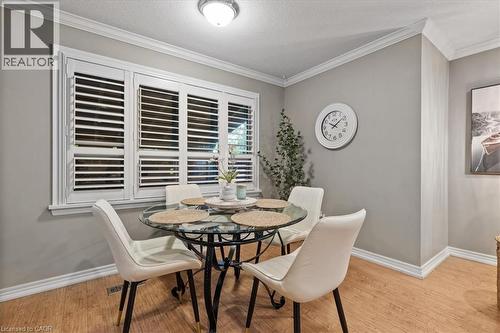 Dining room with ornamental molding, light wood-style flooring, and a textured ceiling - 50 Grove Crescent, Brantford, ON - Indoor Photo Showing Dining Room