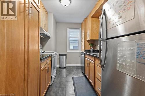 Kitchen with stainless steel appliances, dark countertops, and under cabinet range hood - 50 Grove Crescent, Brantford, ON - Indoor Photo Showing Kitchen