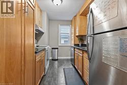 Kitchen with stainless steel appliances, dark countertops, and under cabinet range hood - 