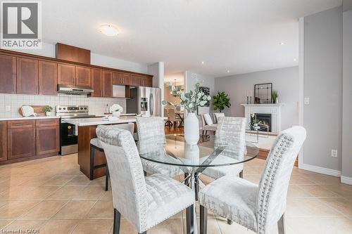 Dining area with light tile patterned floors and a fireplace - 609 Woolgrass Avenue, Waterloo, ON - Indoor Photo Showing Dining Room