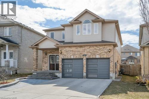 View of front of home with concrete driveway, a garage, brick siding, and a patio - 609 Woolgrass Avenue, Waterloo, ON - Outdoor With Facade