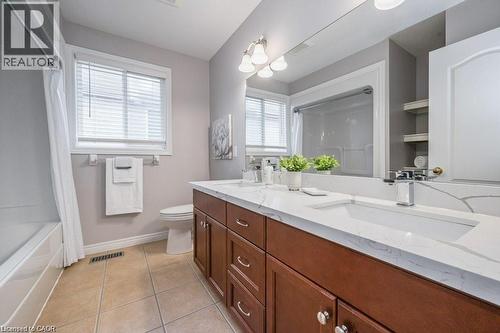Full bathroom featuring double vanity, light tile patterned floors, and shower / bath combination with curtain - 609 Woolgrass Avenue, Waterloo, ON - Indoor Photo Showing Bathroom