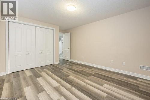 Unfurnished bedroom with a textured ceiling, a closet, and light wood-style flooring - 609 Woolgrass Avenue, Waterloo, ON - Indoor Photo Showing Other Room
